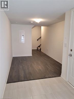 Brantford townhouse for rent - A room with a white door and a staircase in the background.