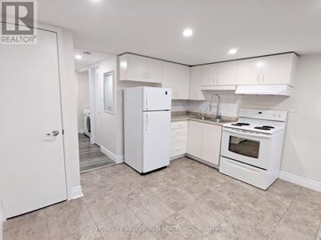 Toronto (Greenwood-Coxwell) apartment for rent - A white kitchen with tile flooring and white appliances.
