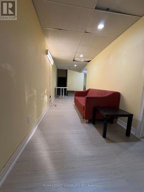 Mississauga (Hurontario) apartment for rent - A long hallway with a red couch and a black table.