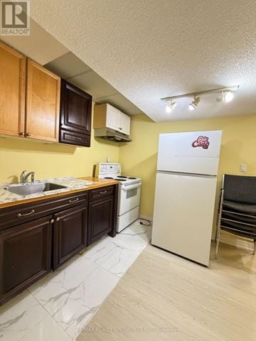 Mississauga (Hurontario) apartment for rent - A kitchen with a white refrigerator and yellow walls.