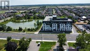 Hamilton condo for rent - A large building with a parking lot in front of it.