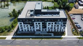 Hamilton condo for rent - A modern building with a flat roof and a parking lot in front.