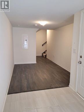 Brantford townhouse for rent - A hallway with a wooden floor and white walls.