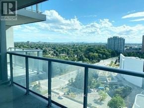 Toronto (Bendale) condo for rent - A balcony with a glass railing overlooks a cityscape.