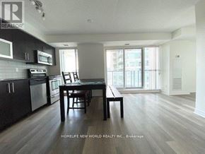 Toronto (Bendale) condo for rent - A kitchen with dark wood floors and white walls.