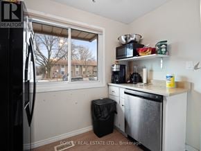 Niagara Falls (Stamford) townhouse for rent - A kitchen with a refrigerator, dishwasher, and a window overlooking a residential area.