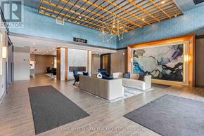 Hamilton (Waterdown) condo for rent - A modern office lobby with a reception desk and a large abstract painting on the wall.