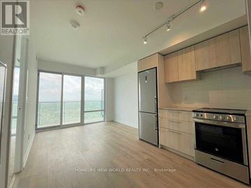 Toronto (Church-Yonge Corridor) condo for rent - A kitchen with a stainless steel refrigerator and oven, wooden cabinets, and a large window with a view.