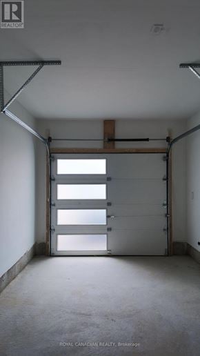 Barrie townhouse for rent - A large open garage door with a light shining through.