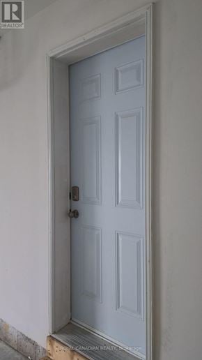 Barrie townhouse for rent - A white door with a black handle and a small square window above the door.