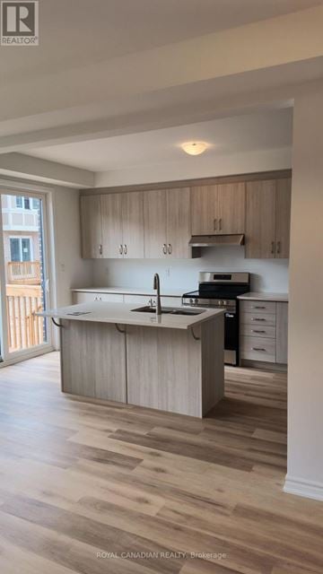 Barrie townhouse for rent - A kitchen with wooden cabinets and a white countertop.