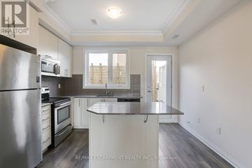 Toronto (Downsview-Roding-Cfb) townhouse for rent - A modern kitchen with a stainless steel refrigerator and microwave.