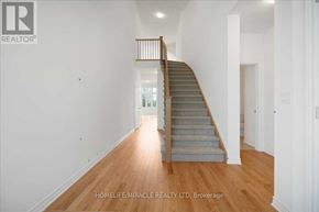 Loyalist (Bath) apartment for rent - A wooden staircase leads up to a brightly lit landing in a white room.
