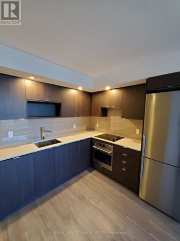 Toronto (Agincourt South-Malvern West) condo for rent - A modern kitchen with dark wood cabinets and stainless steel appliances.