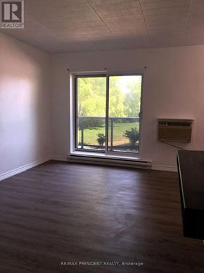 Kitchener condo for rent - A room with a large window and wooden flooring.