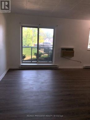 Kitchener condo for rent - A room with a window and a wooden floor.