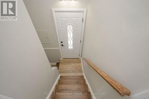Hamilton (Hampton Heights) apartment for rent - A white door with a window in the middle is at the end of a wooden staircase.
