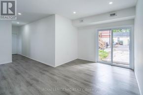 Port Colborne (Main Street) apartment for rent - A spacious room with a sliding glass door leading to a backyard.