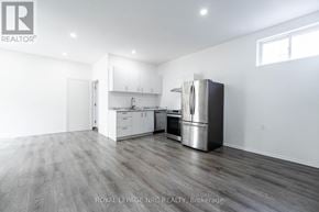 Port Colborne (Main Street) apartment for rent - A spacious kitchen with white cabinets and a stainless steel refrigerator.