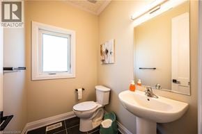 Kitchener apartment for rent - A bathroom with a toilet, sink, and mirror.