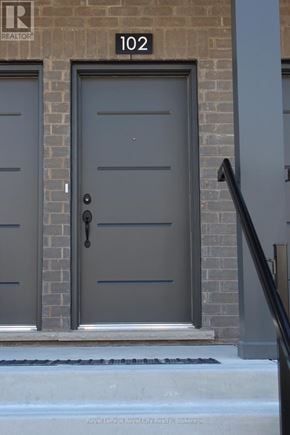Guelph (Clairfields/Hanlon Business Park) townhouse for rent - A grey door with a black handle is on a brick wall.