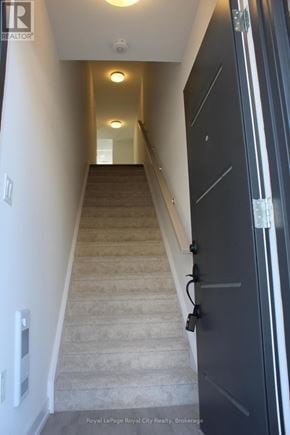 Guelph (Clairfields/Hanlon Business Park) townhouse for rent - A staircase with a black door on the right side.
