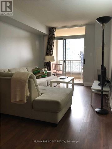 Mississauga (City Centre) condo for rent - A living room with a white couch and a lamp.
