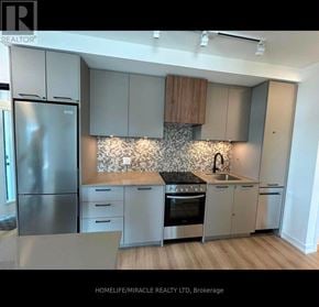 Brampton (Northwest Brampton) condo for rent - A modern kitchen with stainless steel appliances and wooden accents.