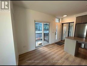 Brampton (Northwest Brampton) condo for rent - A room with wooden flooring and a large window overlooking a balcony.