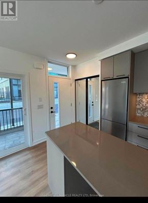 Brampton (Northwest Brampton) condo for rent - A kitchen with a refrigerator, cabinets, and a countertop.