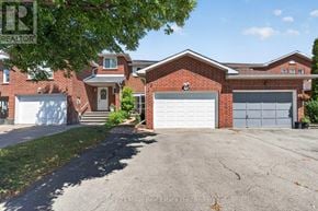 Oakville (Wc Wedgewood Creek) townhouse for rent - A house with a red brick facade and a white garage door.