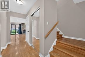 Oakville (Wc Wedgewood Creek) townhouse for rent - A hallway with wooden floors and a staircase leading to the second floor.