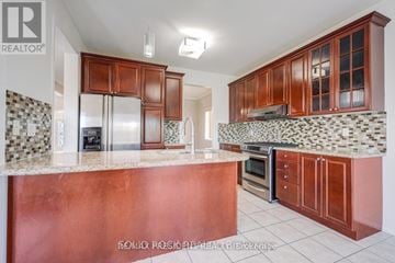 Brampton (Credit Valley) apartment for rent - A kitchen with brown cabinets and a refrigerator.