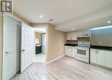 Milton (Be Beaty) apartment for rent - A kitchen with white cabinets and a stove top oven.