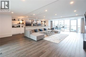Grimsby condo for rent - A spacious living room with a white sofa set and a wooden floor.