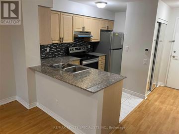 Toronto (Bendale) condo for rent - A kitchen with a granite countertop and a refrigerator.