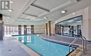 Toronto (Edenbridge-Humber Valley) condo for rent - A large indoor swimming pool with a glass wall on one side.
