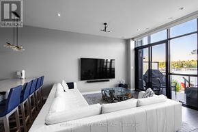 Innisfil townhouse for rent - A modern living room with a large white couch and a flat screen TV mounted on the wall.