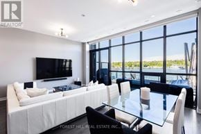 Innisfil townhouse for rent - A modern living room with a large white sofa and a glass table.