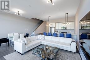 Innisfil townhouse for rent - A modern living room with a white sofa and a glass coffee table.