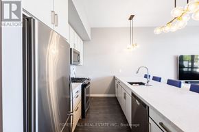 Innisfil townhouse for rent - A modern kitchen with a stainless steel refrigerator and a white countertop.