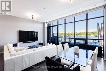 Innisfil townhouse for rent - A modern living room with a large white sofa and a glass table.