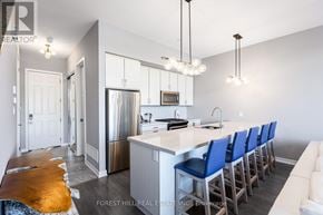 Innisfil townhouse for rent - A kitchen with a long island and blue chairs.