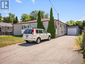 Richmond Hill (Crosby) apartment for rent - A white car is parked in front of a house with a sign that says REALTOR.
