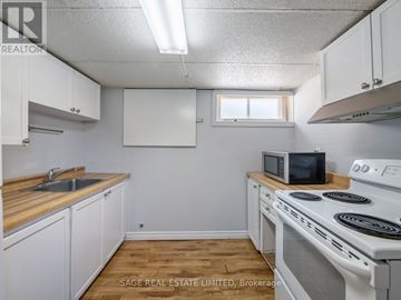 Richmond Hill (Crosby) apartment for rent - A small kitchen with white cabinets and a white stove top oven.