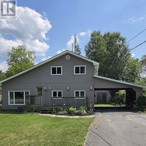 Huntsville apartment for rent - A grey house with a black fence and a green lawn.