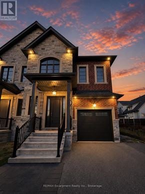 Oakville (Co Central) apartment for rent - A house with a stone facade and a black garage door is shown.