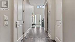 Oakville (Co Central) apartment for rent - A hallway with white doors and a brokerage sign on the wall.