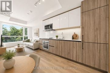 Toronto (South Riverdale) condo for rent - A modern kitchen with wooden cabinets and a large window.