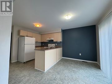 Barrie (Painswick South) apartment for rent - A kitchen area with a refrigerator, microwave, and oven.